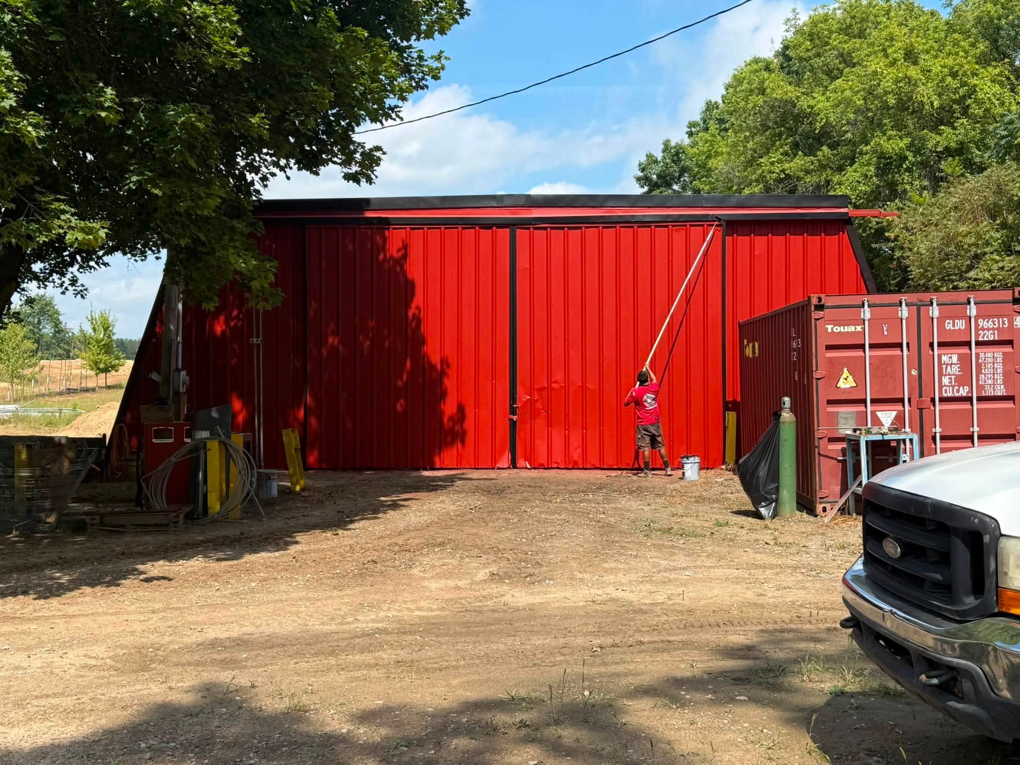 Red metal building repaint in progress